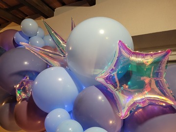 Reflet d'une étoile suspendue dans une étoile intégrée à la décoration en ballons. Pics de primadescent starburst au milieu des ballons bleu et violet