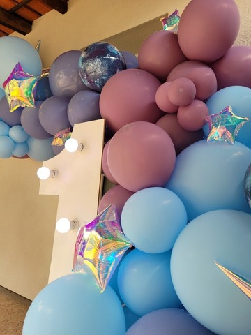 Chiffre lumineux géant entouré de ballons bleu et violet avec des étoiles