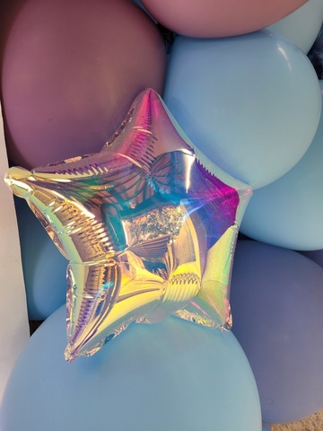 Étoile aux reflets multicolores dans une arche de ballons pour un anniversaire