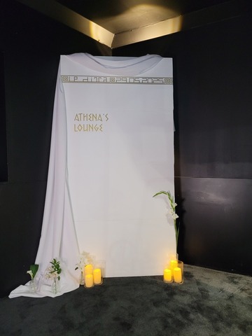 Fond blanc avec texte doré, décoré d'un drapé et habillé de fleurs et bougies