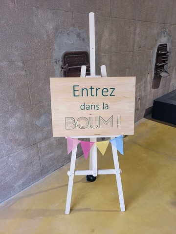 Panneau d'accueil sur chevalet en bois et fanions colorés