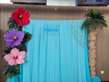 Décor pour la sortie du film Vaiana avec palmier et plantes tropicales artificielles. Cascade en tissus légers et panneau fait main