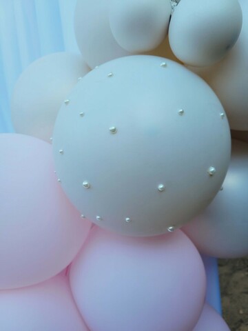 Focus sur un ballon nacré décoré de petites perles. Un rendu élégant et un détail original qui change l'arche de ballons de simple à originale grâce à un détail discret